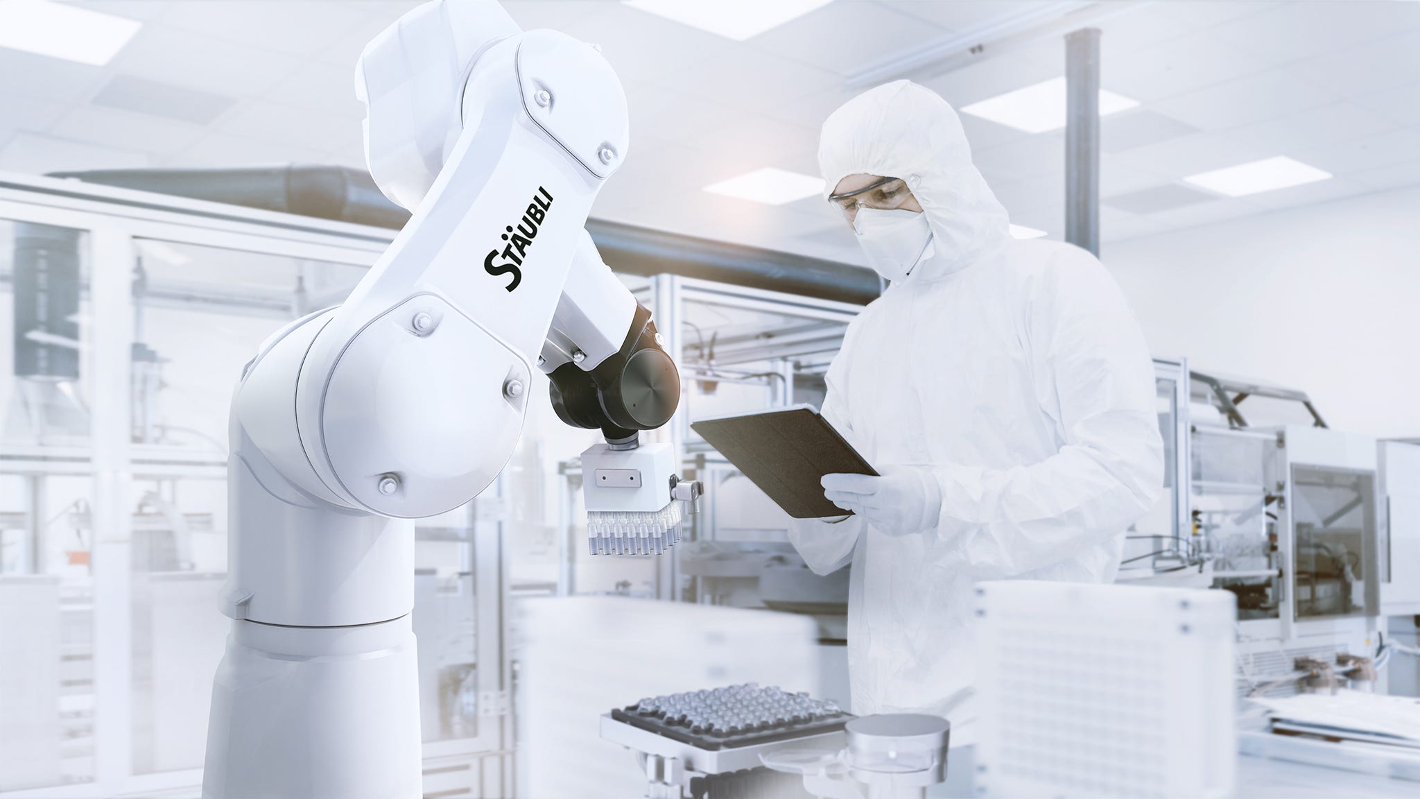 Industrial robot Stericlean operates in a pharmaceutical environment. Quality Control Check: Scientist Using Digital Tablet Computer and wearing Protective Suit walks through Manufacturing Laboratory. Product Manufacturing: Pharmaceutics, Biotechnology.