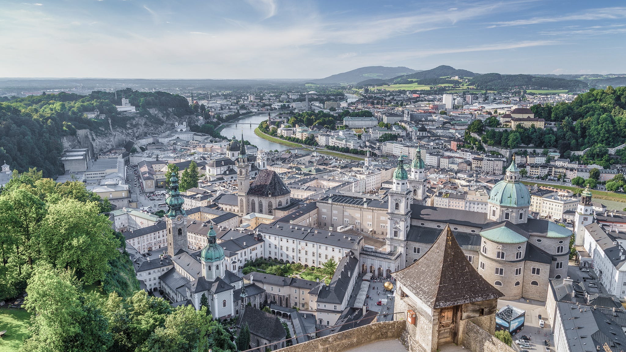 Aerial panoramic view of the historic city of Salzburg with Salzach river in beautiful golden evening light with blue sky and clouds at sunset in summer, Salzburger Land, Austria