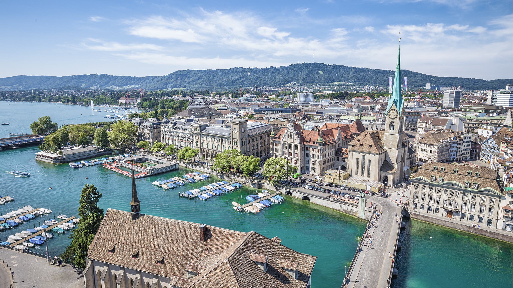 Aerial view of historic Zurich city center with famous Fraumunster Church and river Limmat at Lake Zurich from Grossmunster Church on a sunny day with clouds in summer, Canton of Zurich, Switzerland