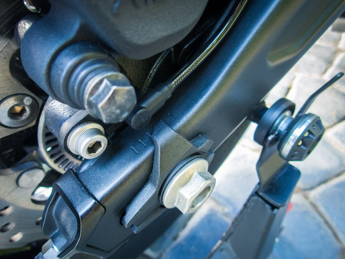 Rear wheel chain sprocket alignment marks on hydroformed aluminum swingarm of a sportbike with disc brake and caliper visible