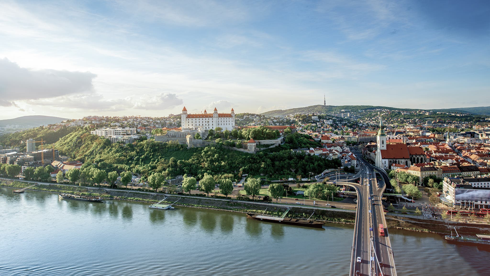 Bratislava aerial cityscape view on the old town with Saint Martin's cathedral, castle hill and Danube river on the sunset in Slovakia. Wide angle view with copy space