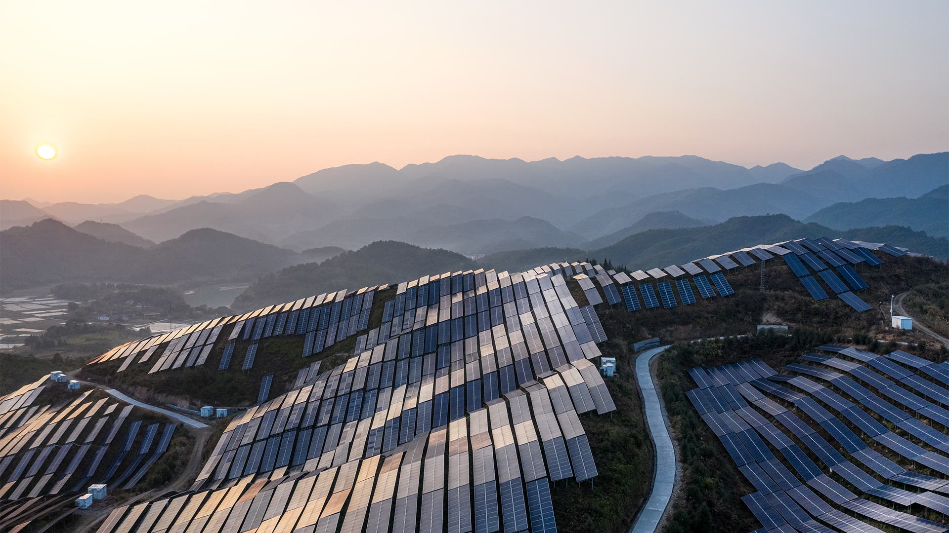 Aerial view of the solar power plant on the top of the mountain at sunset