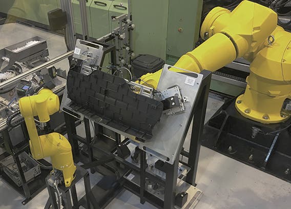 Two Stäubli six-axis robotic arms perform a combination of demolding and assembly of molded parts