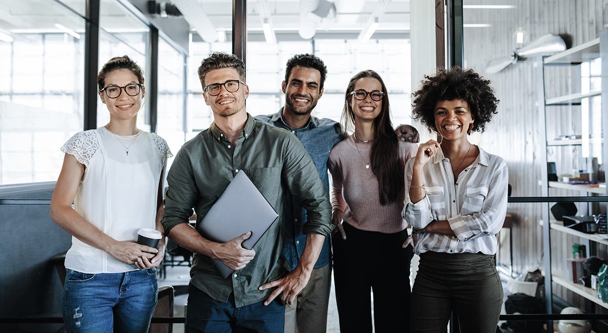 Picture of a successful creative business team looking at camera and smiling.