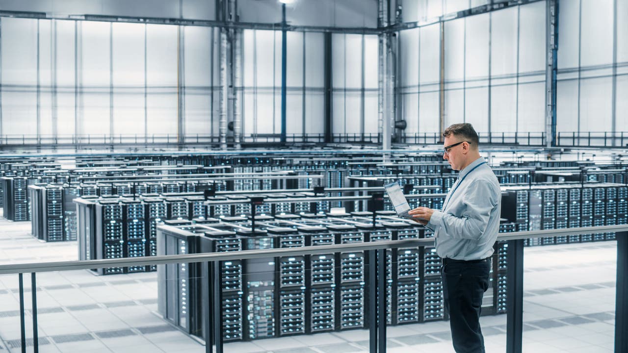 Data Center Engineer Using Laptop Computer. Server Farm Cloud Computing Specialist Facility with Adult Male System Administrator Working with Data Protection Network for Cyber Security.; Shutterstock ID 2052013328; purchase_order: Jasmin Zehnder