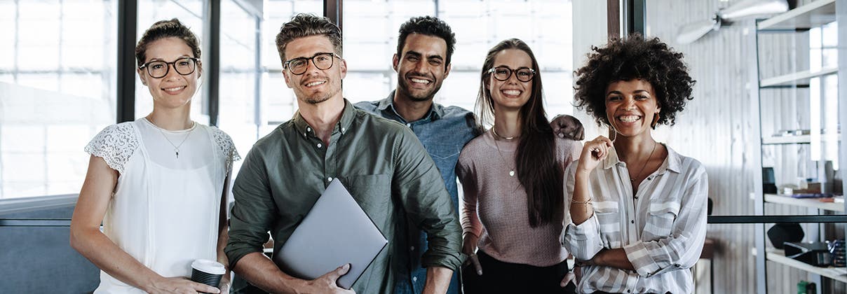 Picture of a successful creative business team looking at camera and smiling.