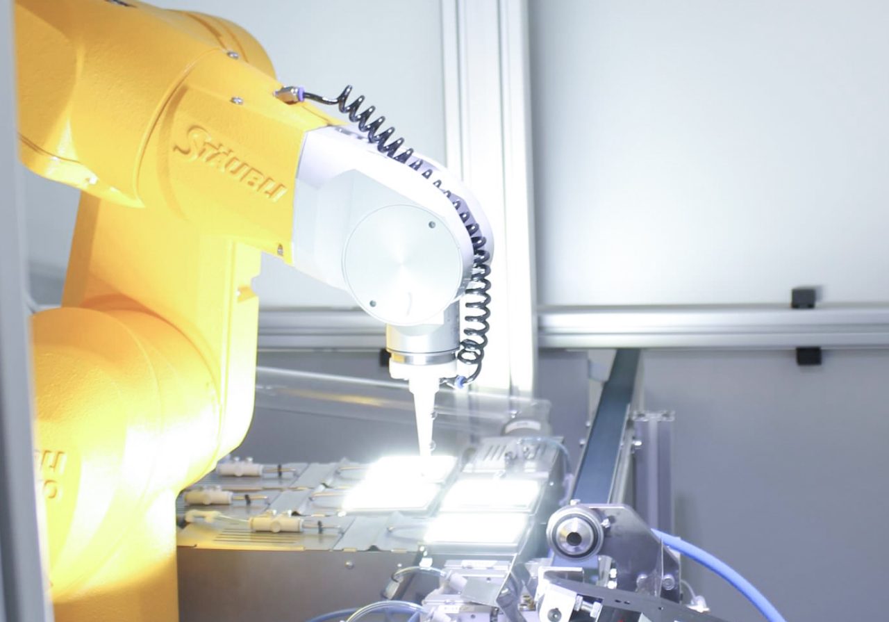 A compact Stäubli TX40 6-axis industrial robot takes the handling of the teeth.