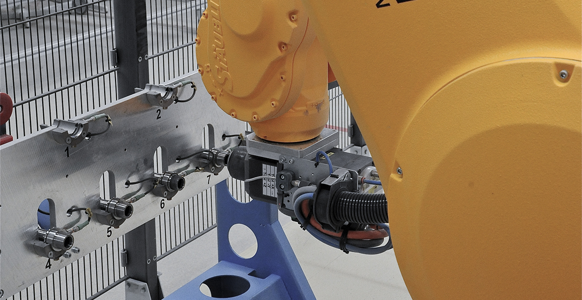 The robot cell is equipped with an automatic tool changing station.